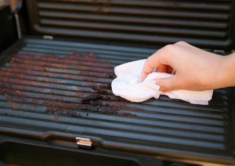Hand Using A Rag To Clean Electric Grill