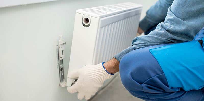 Man Taking Out Radiator From The Wall