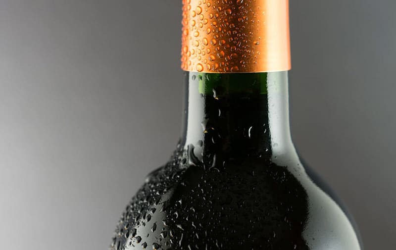 Half of wine bottle with droplets on it