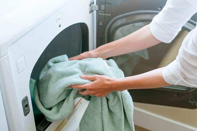 Woman Taking Out Towel From Dryer