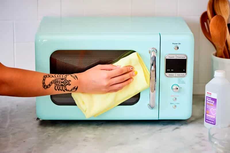 Hand With Tatto Cleaning Microwave Door