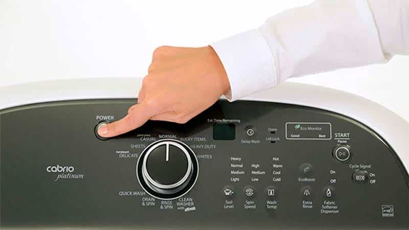 Hand Pressing Power Button On Washer 