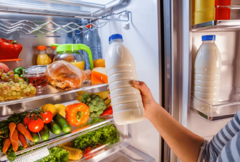 checking a bottle of milk from the refrigerator 