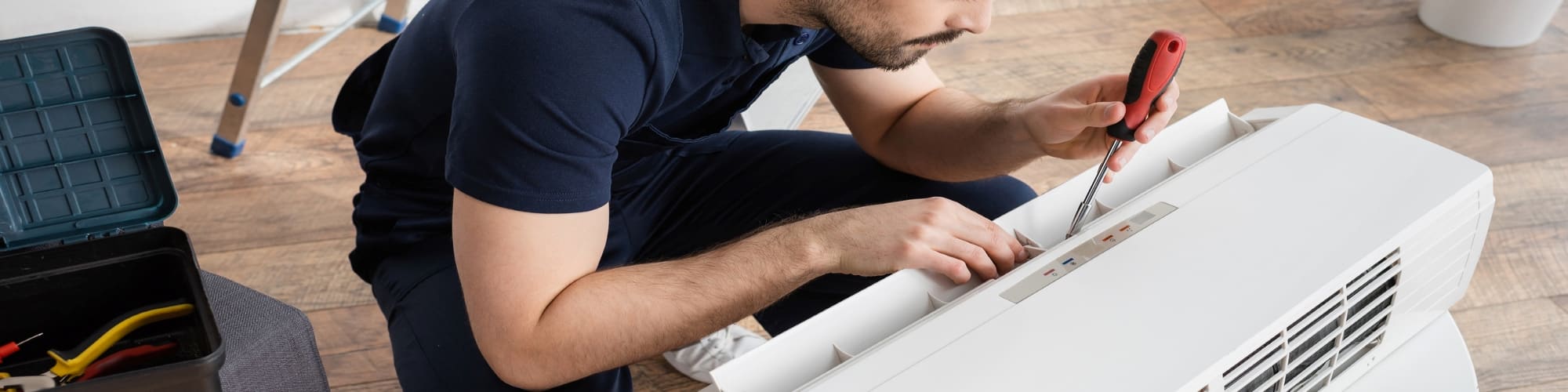 A man repairing an Air Conditioner