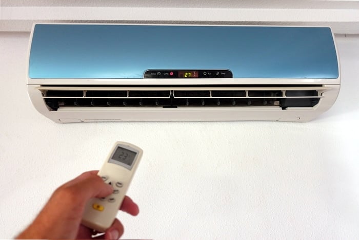 A person adjusting the settings of an Air Conditioner