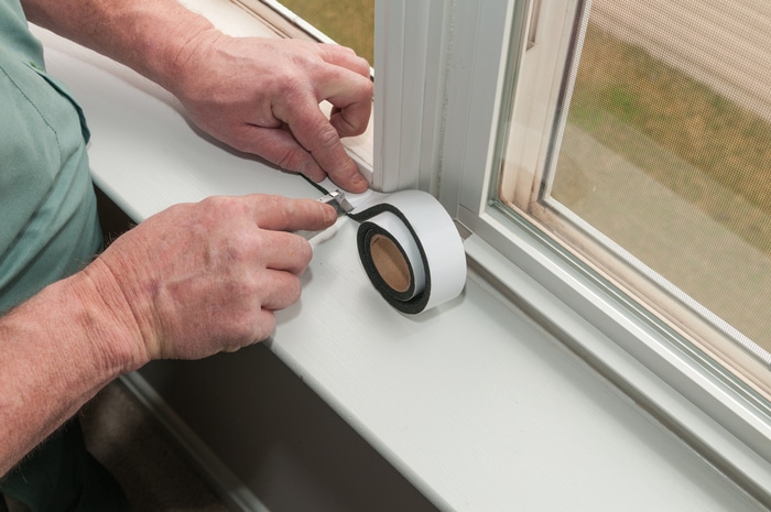 A person insulating a window