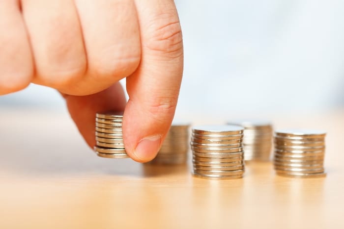 A person placing coins on a table