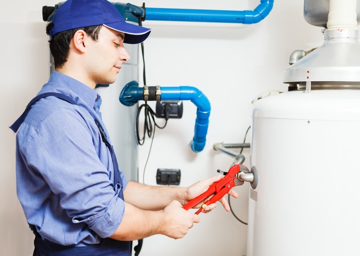 A plumber working on a water heater