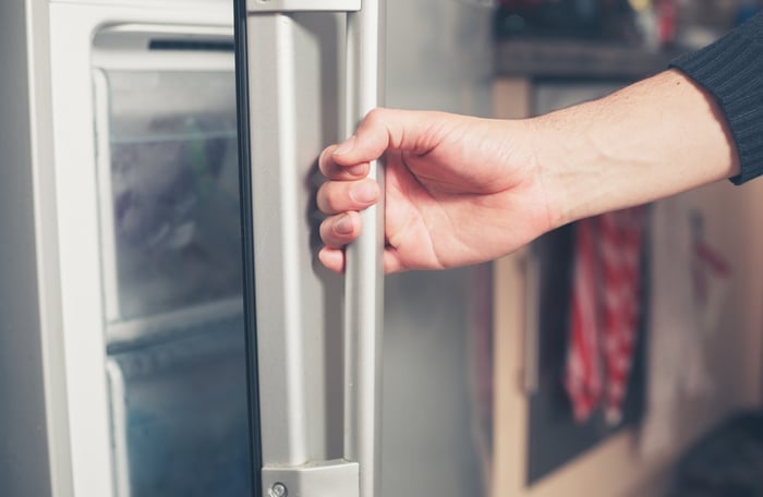 A person opening a freezer door