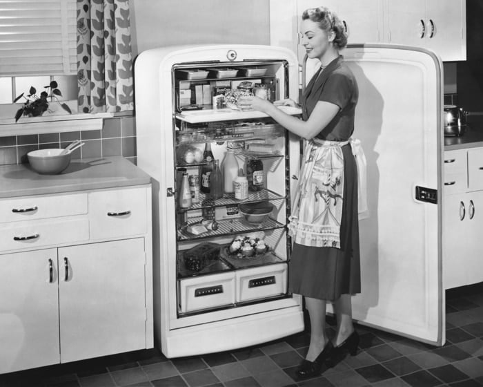 A woman looking inside a fridge in black and white