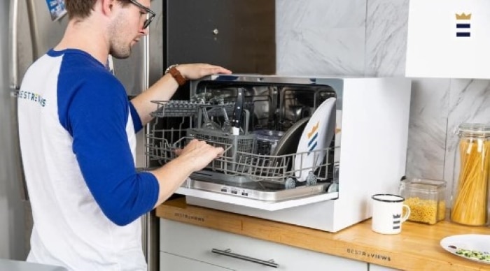 A man opening a countertop dishwasher