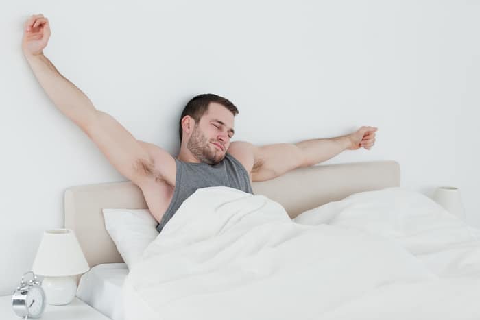A man stretching in bed