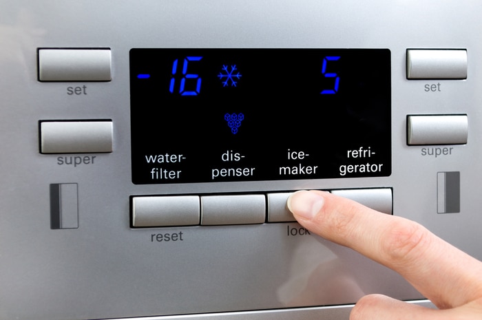 A person dialing settings into an ice maker