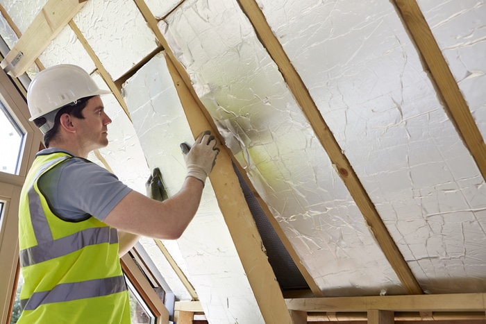 A man installing insulation