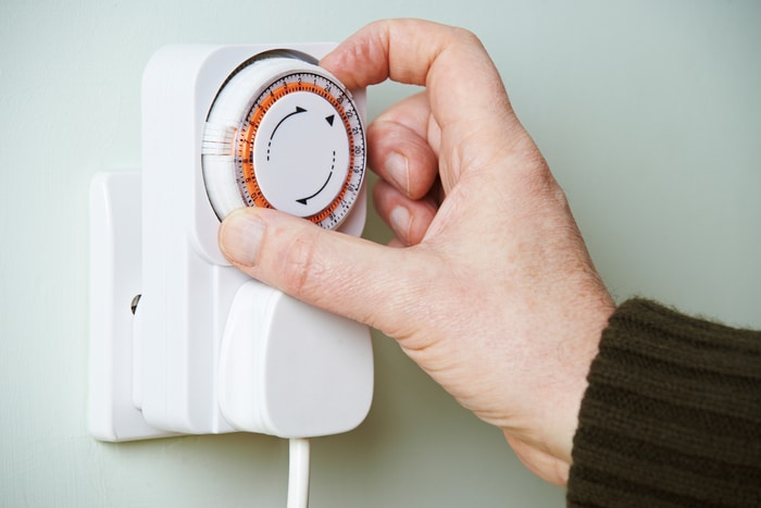 A person adjusting a plug timer