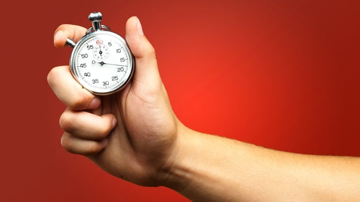 A person holding a timer in a red background