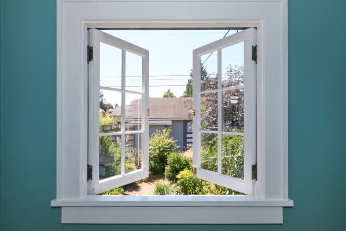 An open window with a view of a backyard