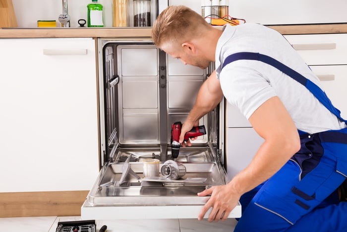 A technician repairing a dishwasher