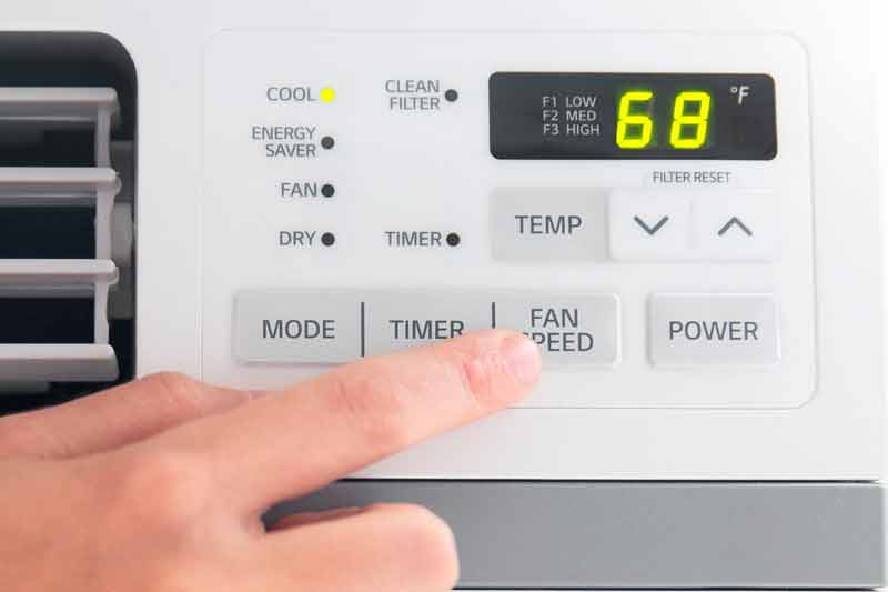 Setting temperature settings on a portable air conditioner.