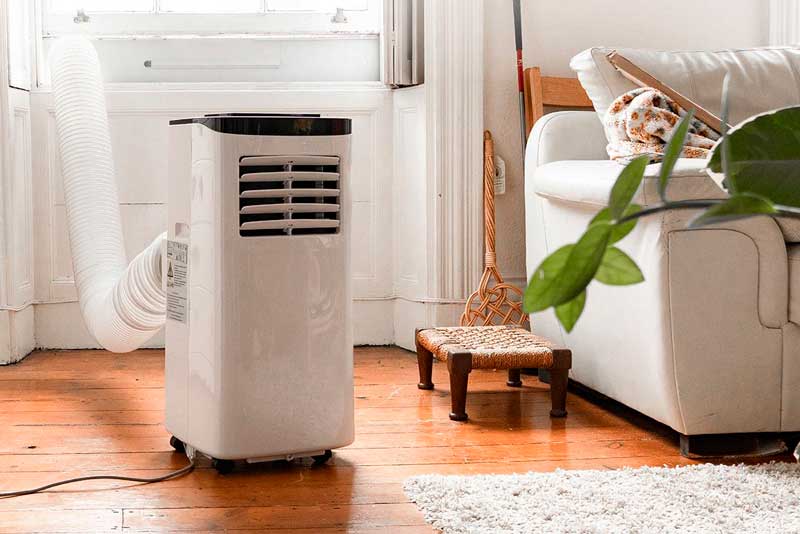 Frontal photo of a portable air conditioner in a well-lit living room.