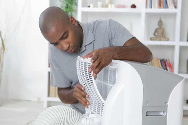 Man inspecting inside of Portable Ac