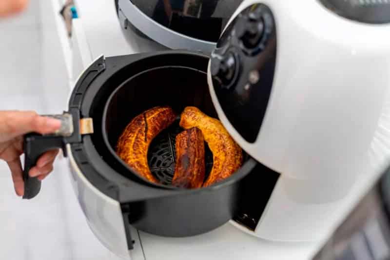 Overcooked food inside of a white air fryer