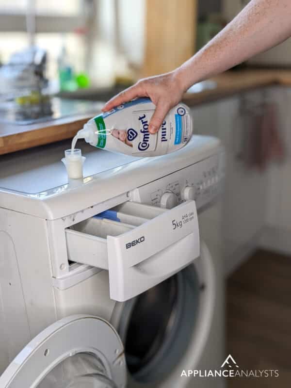 Pouring fabric softener in washer