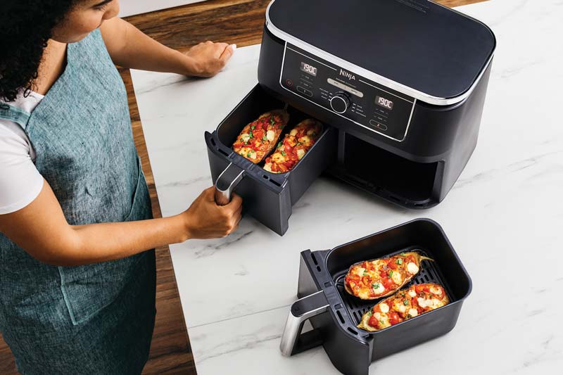 Woman cooking in a Dual Basket Air Fryer