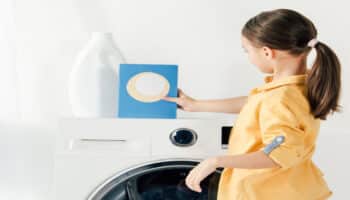 Child standing next to washer