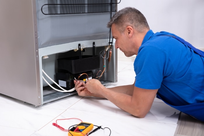 Technician repairing fridge