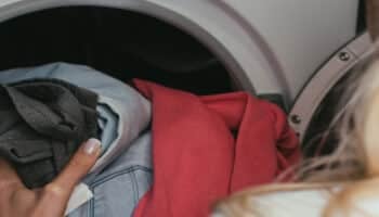 Woman placing clothes inside a washer